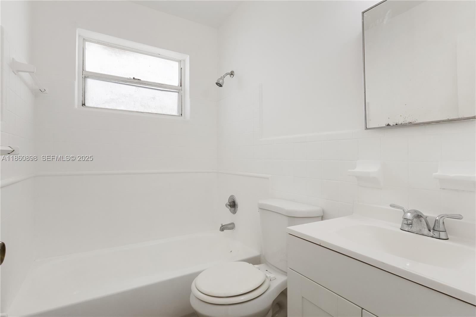 1251 Northwest 59th Street, Unit 3 Miami, FL 33142 - Photo 7 of 22 a white toilet sitting next to a bath tub