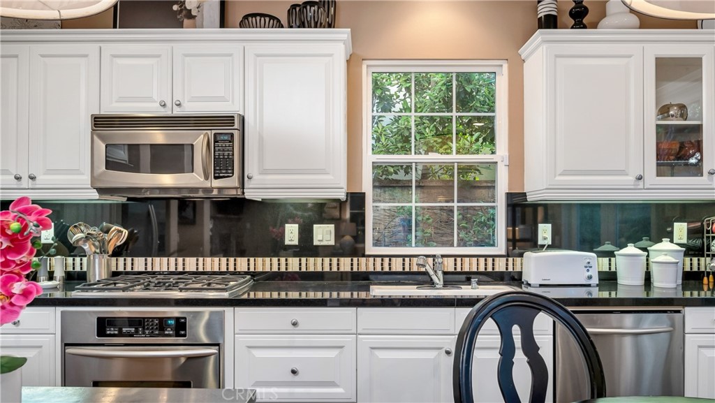 55 Bower Tree Irvine, CA 92603 - Photo 7 of 29 a kitchen with granite countertop a stove a sink and a microwave