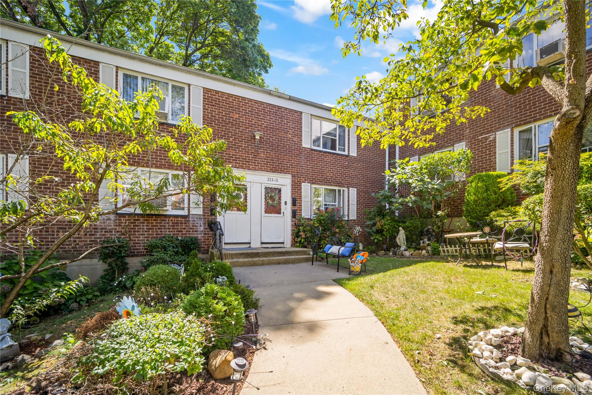 223-11 Manor Road, Unit UPPR Queens, NY 11427 - Photo 16 of 16 a front view of a house with a yard