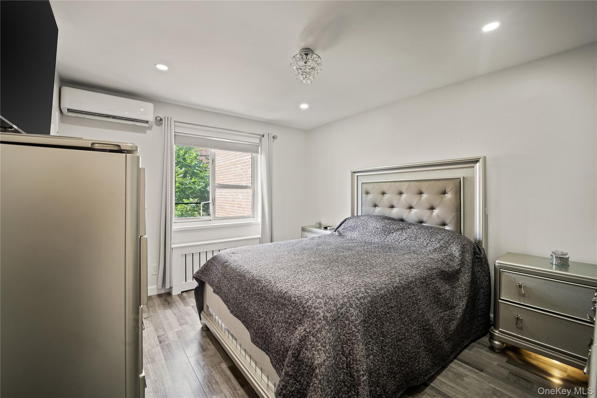 223-11 Manor Road, Unit UPPR Queens, NY 11427 - Photo 5 of 16 a bedroom with a bed and a flat screen tv