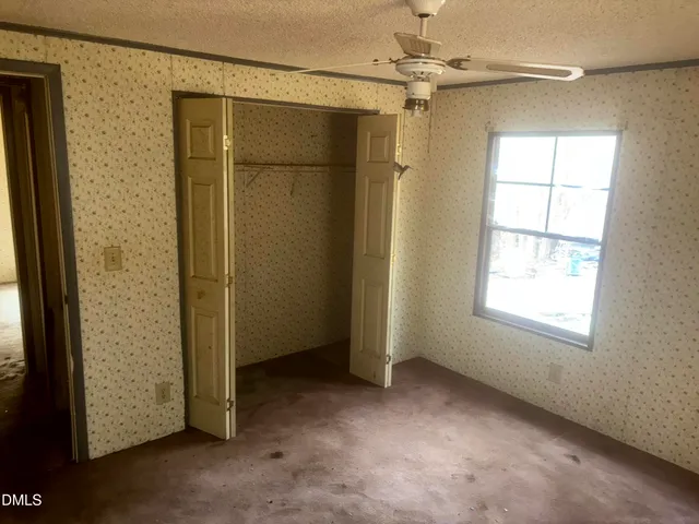 an empty room with windows and closet