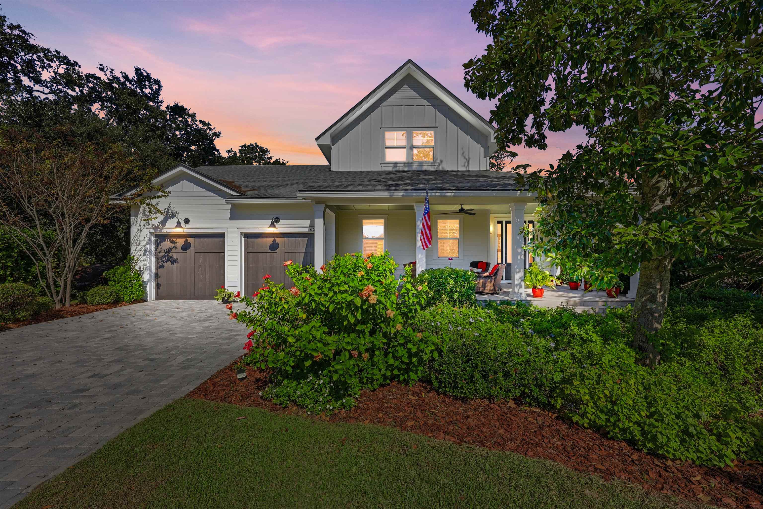 a front view of a house with a yard and trees