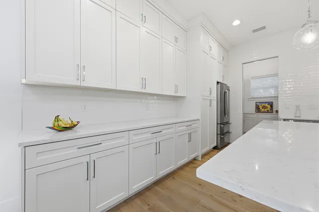 a kitchen with stainless steel appliances white cabinets and a refrigerator