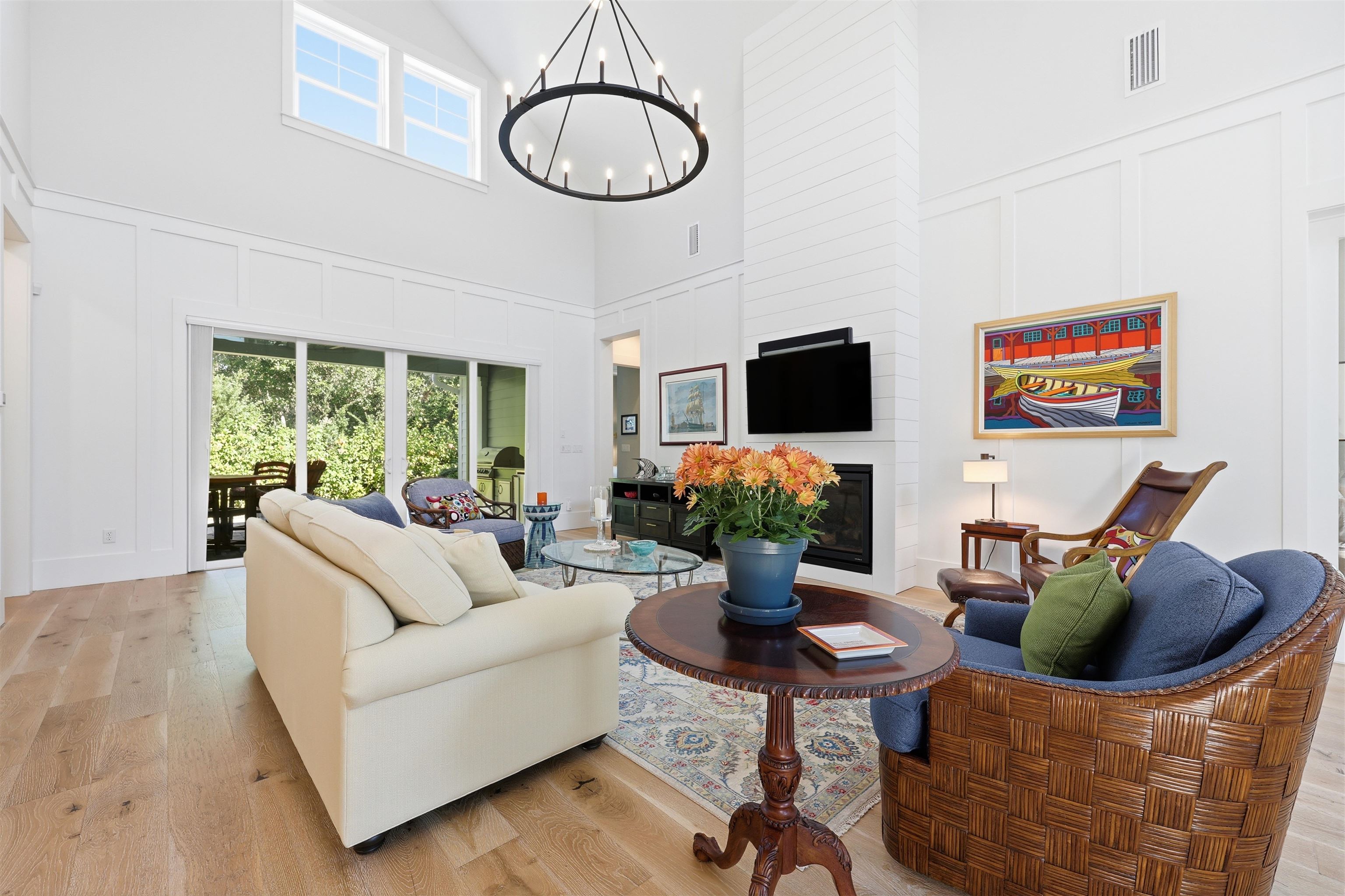 66 Ridgeway Road St. Augustine, FL 32080 - Photo 38 of 53 Living room with a decorative wall, light wood-type flooring, a glass covered fireplace, plenty of natural light, and a chandelier