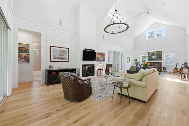 a living room with furniture a flat screen tv and kitchen view