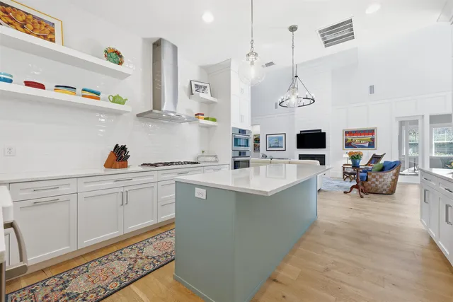 a large white kitchen with lots of clutter and stainless steel appliances