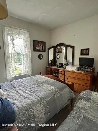 a bedroom with a bed and dresser with mirror