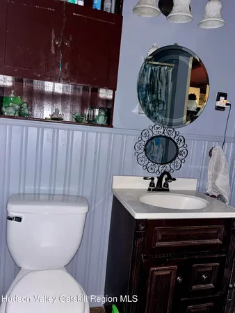 a bathroom with a toilet a sink and mirror