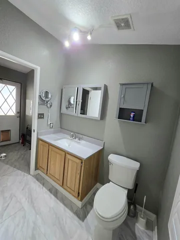 a bathroom with a toilet sink and mirror