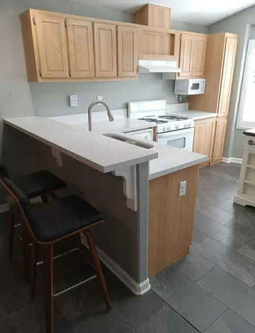 a kitchen with stainless steel appliances a sink stove and cabinets