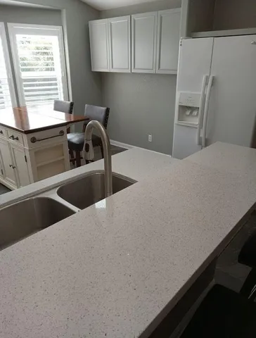 a kitchen with a refrigerator and a sink