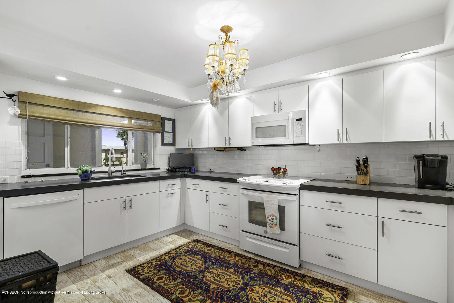250 South Beach Road, Unit 208 Jupiter, FL 33469 - Photo 3 of 14 a kitchen with granite countertop white cabinets white appliances a sink and a window