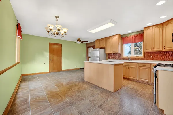 a kitchen with stainless steel appliances granite countertop a stove top oven a refrigerator and a sink