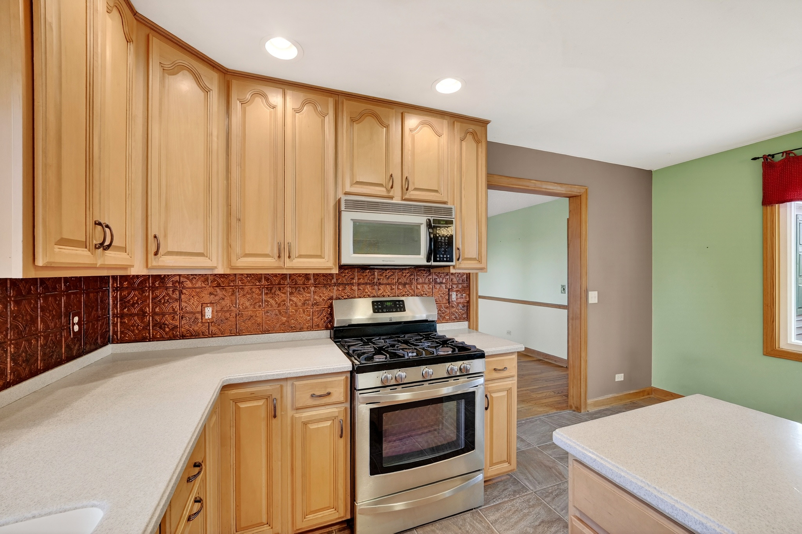 21230 Virginia Road DeKalb, IL 60115 - Photo 17 of 54 a kitchen with stainless steel appliances granite countertop a stove a sink and a microwave