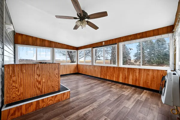 a view of a livingroom with wooden floor and a ceiling fan