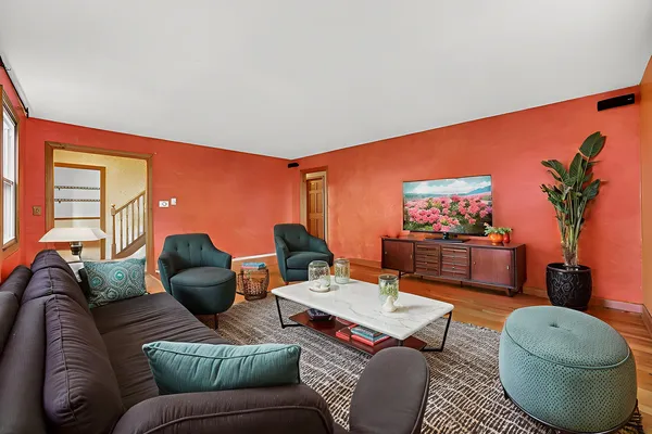 an empty room with wooden floor chandelier fan and windows