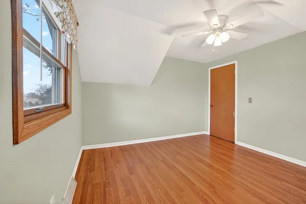 an empty room with windows and fan