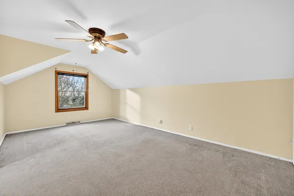 an empty room with a window and a ceiling fan