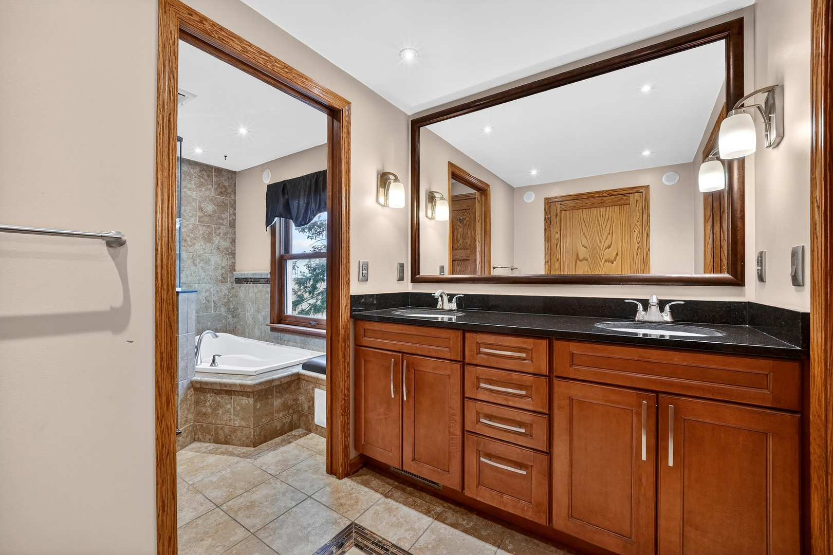 21230 Virginia Road DeKalb, IL 60115 - Photo 44 of 54 a spacious bathroom with a double vanity sink a mirror and a bathtub