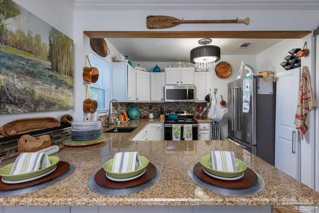 a kitchen with stainless steel appliances a stove and a wooden floor