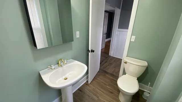 a bathroom with a toilet sink and mirror