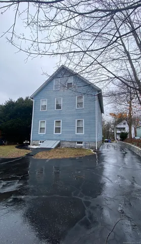 a brick house with yard and a large tree