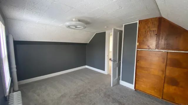 a view of a refrigerator in kitchen and an empty room