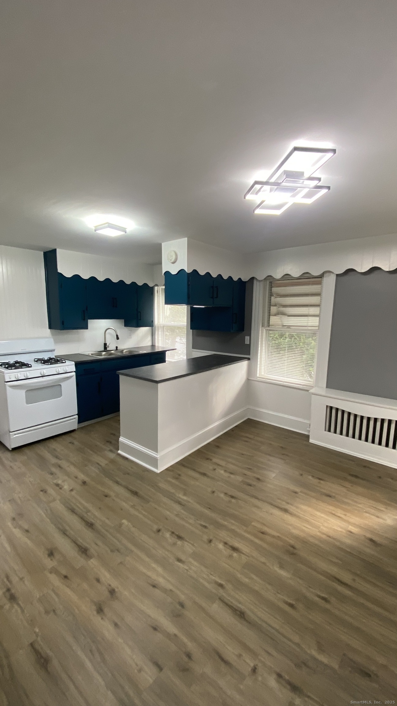 26 Pine Street, Unit 2 Torrington, CT 06790 - Photo 4 of 36 a view of kitchen and empty room with wooden floor