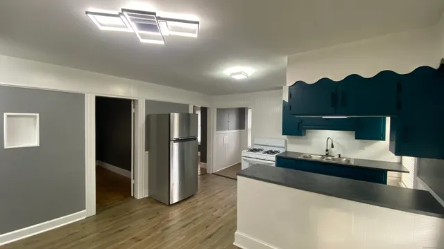 a living room with hard wood flooring and white cabinets