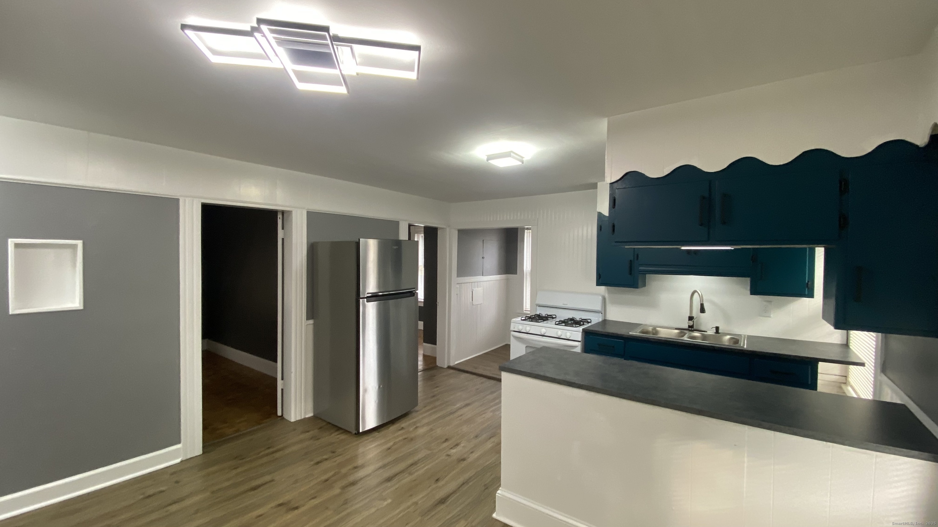 26 Pine Street, Unit 2 Torrington, CT 06790 - Photo 5 of 36 a living room with hard wood flooring and white cabinets