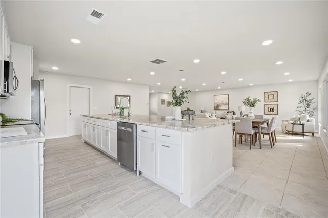 a large white kitchen with lots of counter top space and center island