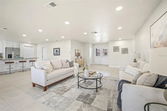 a living room with furniture and view of kitchen