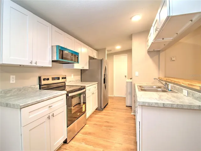 a kitchen with a sink stove top oven and cabinets