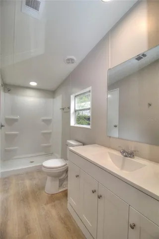 a bathroom with a toilet a sink a mirror a bathtub and shower
