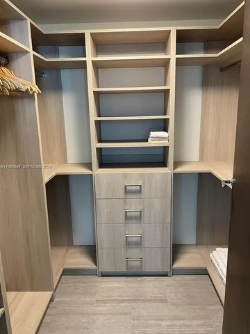 a view of walk in closet with empty racks