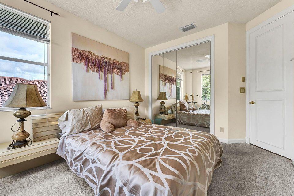3271 Harrington Drive Boca Raton, FL 33496 - Photo 21 of 43 a bedroom with a large bed and a chandelier