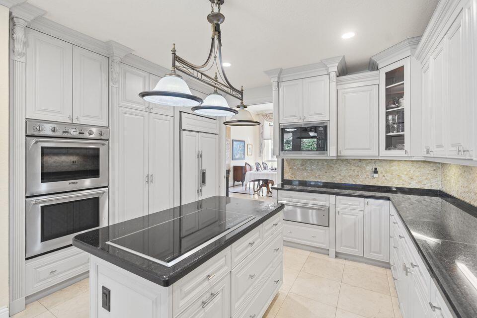 3271 Harrington Drive Boca Raton, FL 33496 - Photo 10 of 43 a kitchen with kitchen island a counter appliances a sink and cabinets