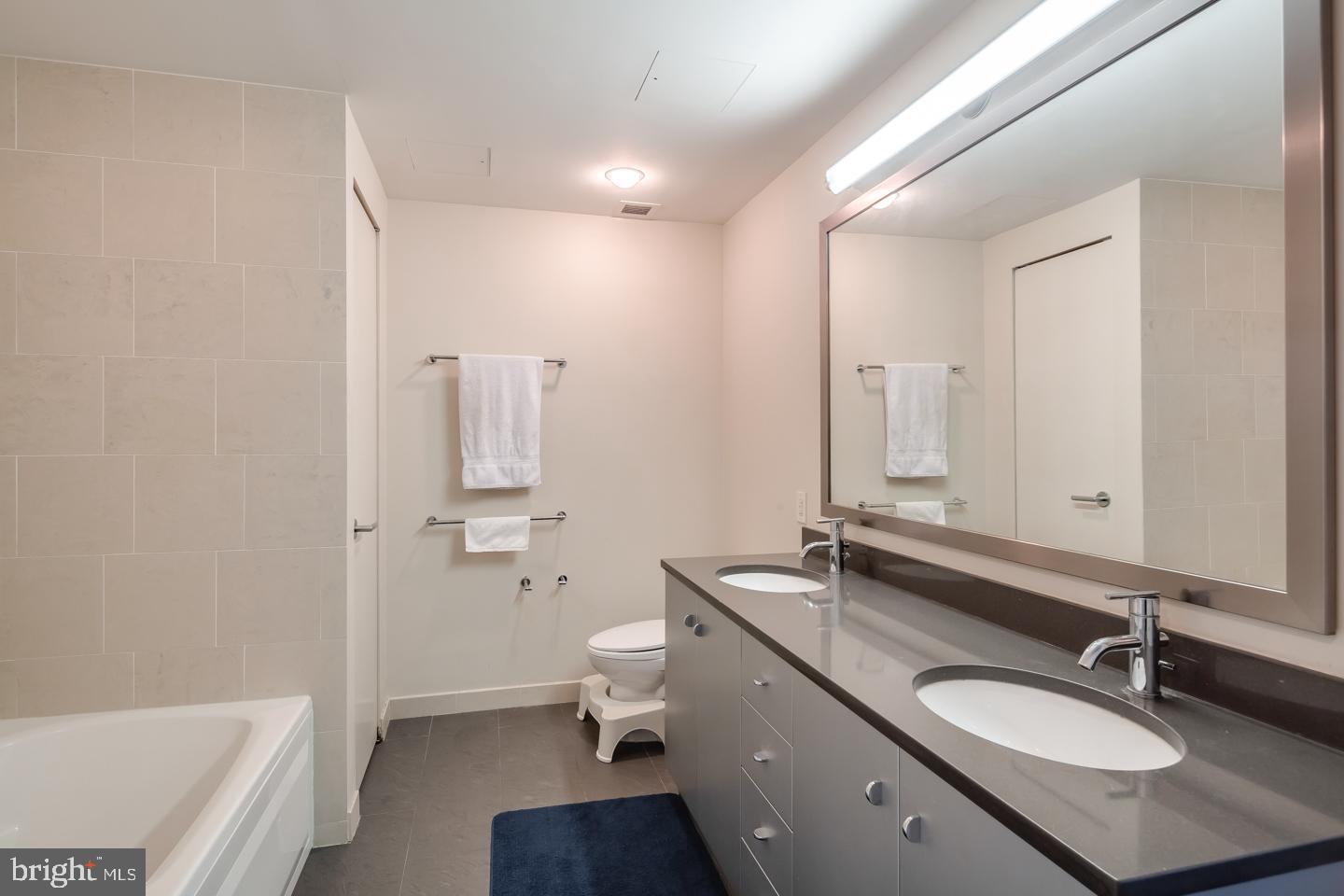2101 Market Street, Unit 1901 Philadelphia, PA 19103 - Photo 12 of 25 a bathroom with a granite countertop sink toilet and shower
