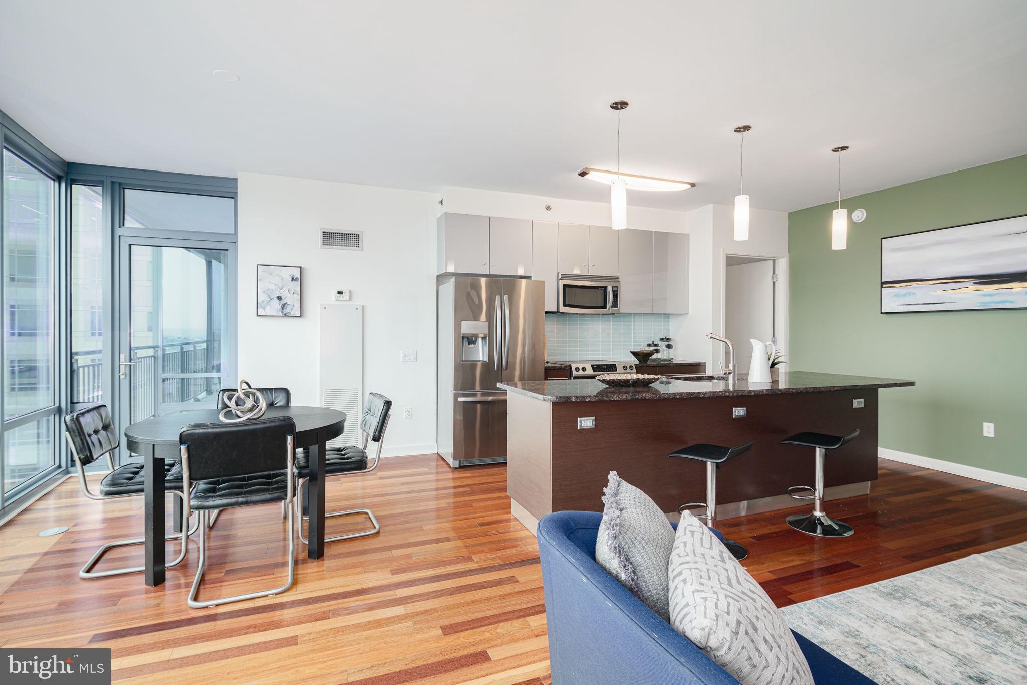 2101 Market Street, Unit 1901 Philadelphia, PA 19103 - Photo 4 of 25 a living room with stainless steel appliances kitchen island granite countertop furniture and wooden floor