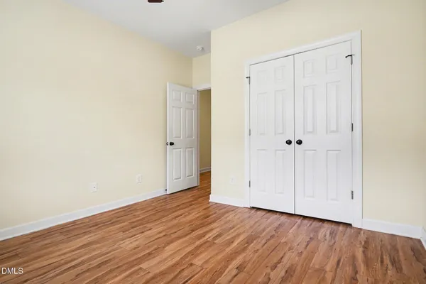 a view of an empty room with wooden floor