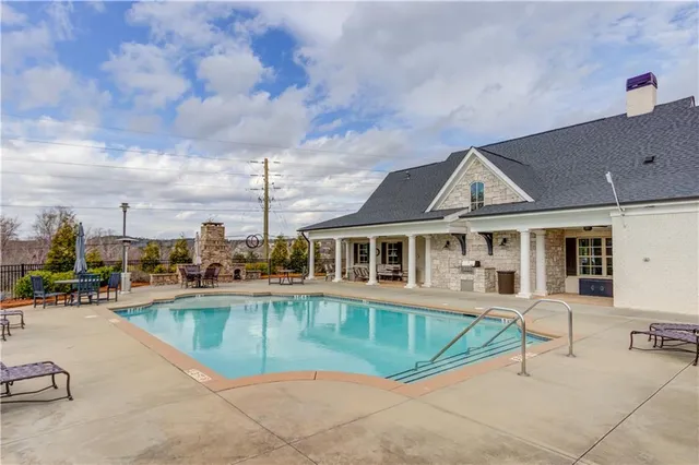 a view of a house with swimming pool and sitting area