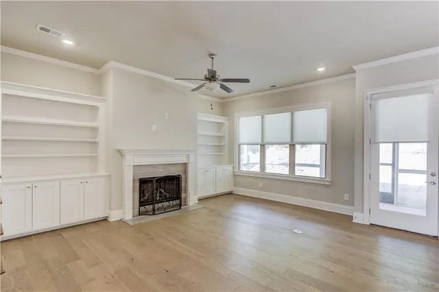 an empty room with windows and fireplace