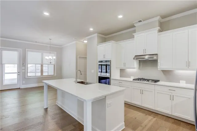 a kitchen with granite countertop white cabinets and white appliances