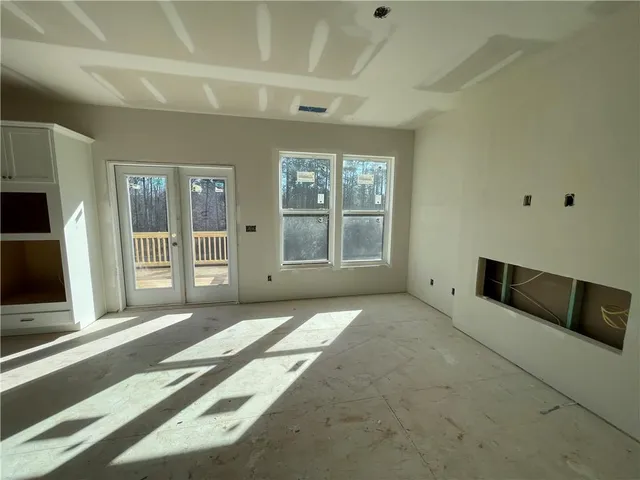a view of an empty room with a fireplace and a window