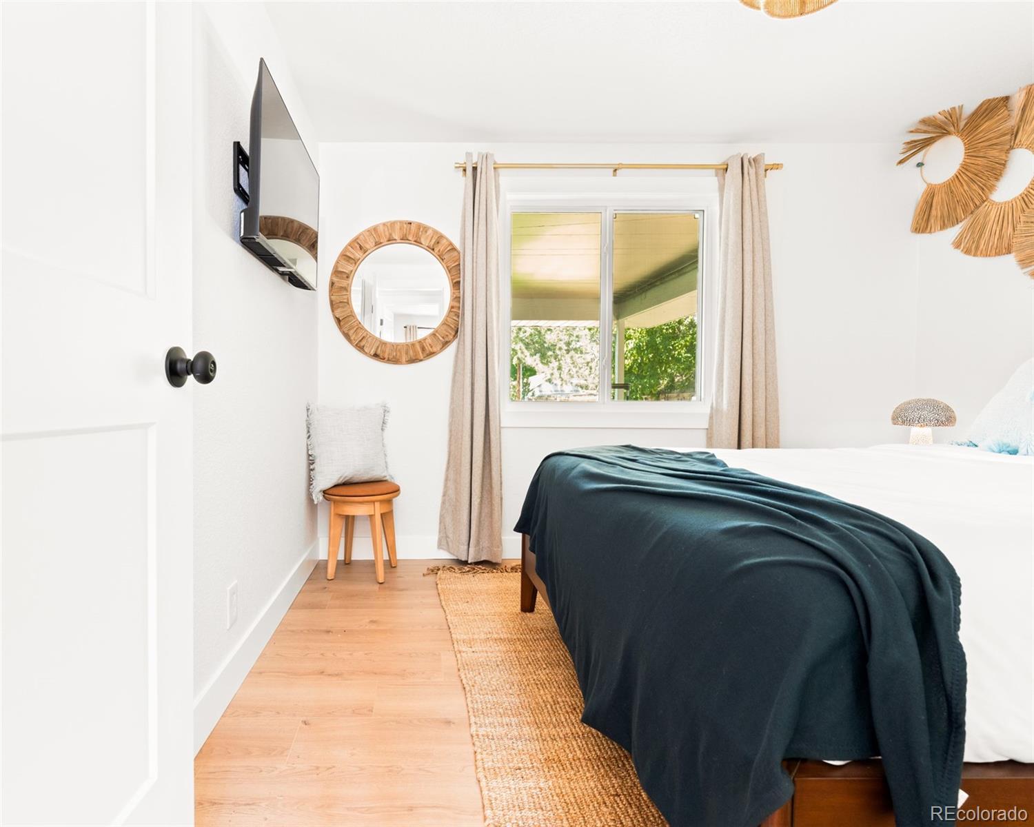 6115 Chase Street Arvada, CO 80003 - Photo 14 of 45 a living room with a bed and a large window