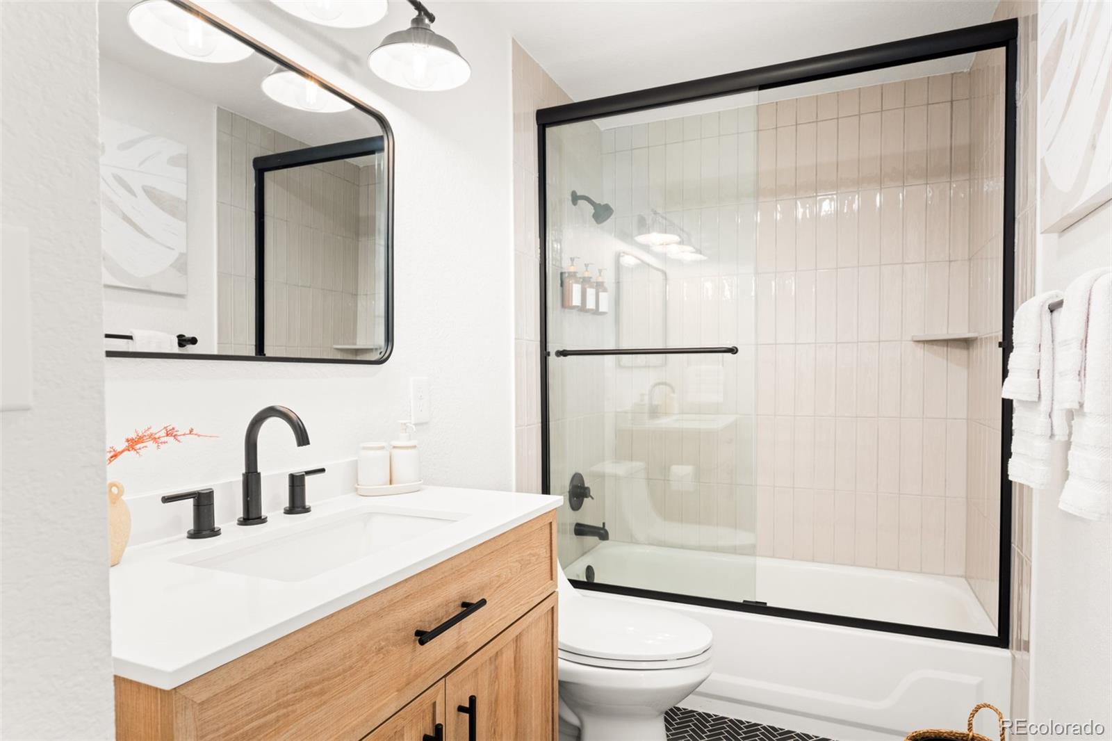 6115 Chase Street Arvada, CO 80003 - Photo 17 of 45 a bathroom with a sink mirror toilet and shower