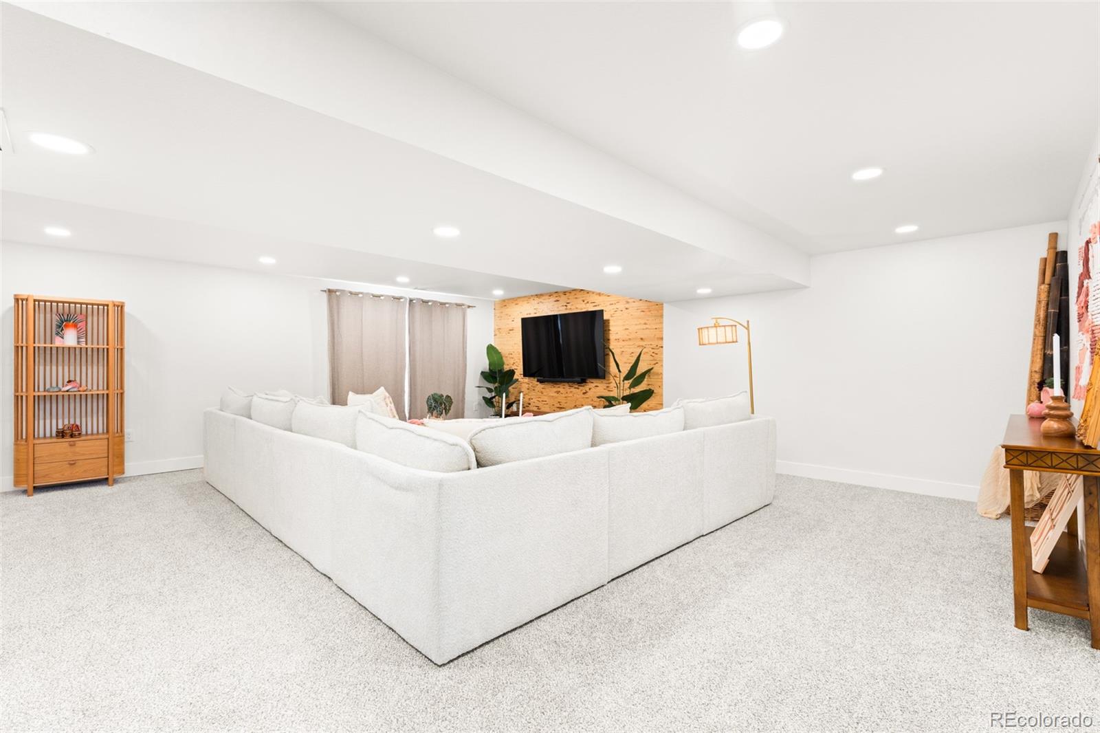 6115 Chase Street Arvada, CO 80003 - Photo 30 of 45 a living room with furniture and a flat screen tv
