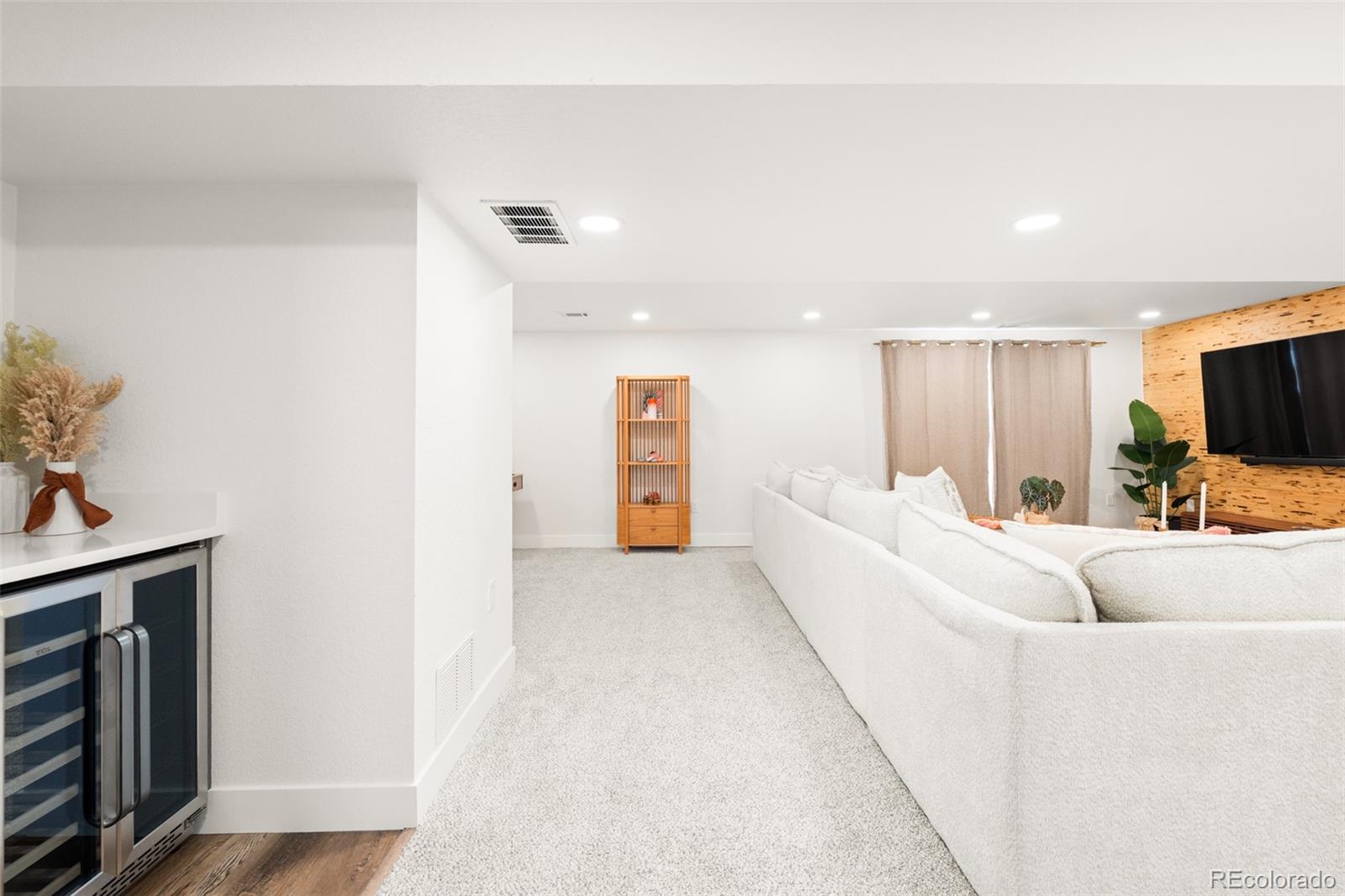 6115 Chase Street Arvada, CO 80003 - Photo 31 of 45 a living room with furniture and a flat screen tv