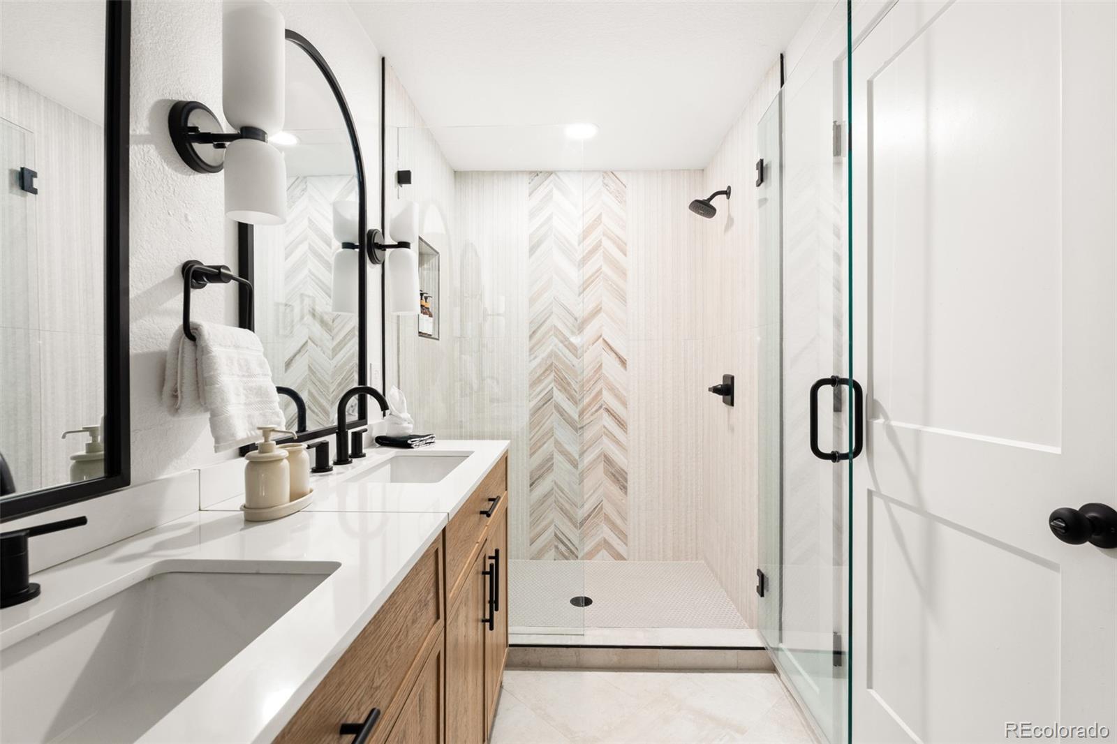 6115 Chase Street Arvada, CO 80003 - Photo 32 of 45 a bathroom with a granite countertop sink vanity mirror and shower