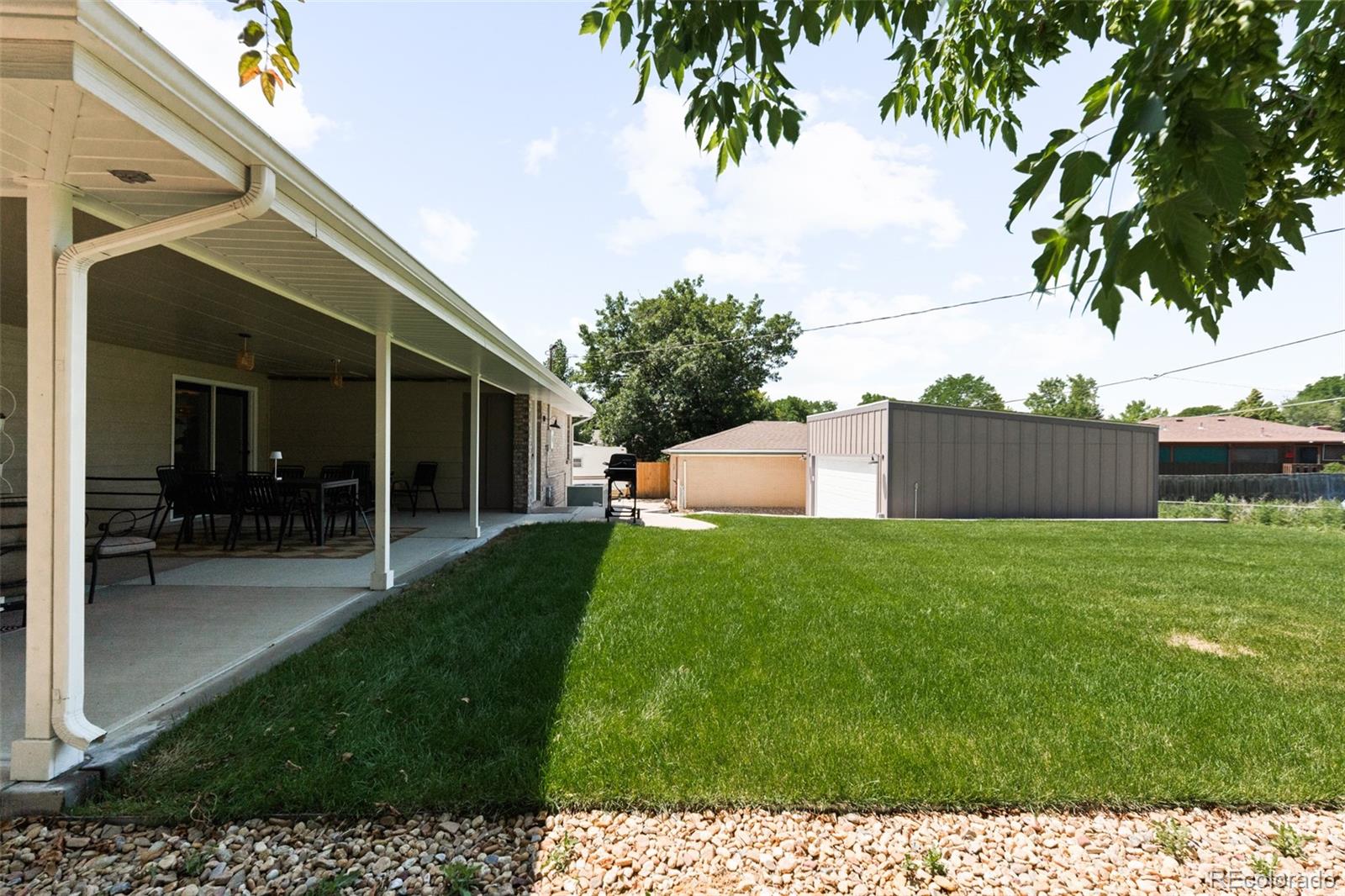 6115 Chase Street Arvada, CO 80003 - Photo 44 of 45 a backyard of a house with table and chairs
